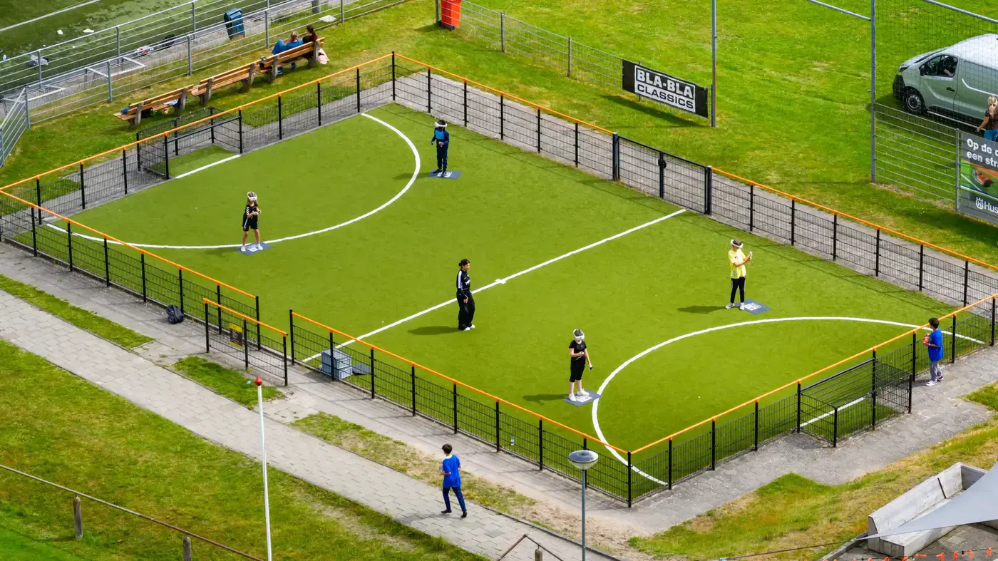 Luchtfoto van een kunstgras panna-voetbalveld met spelende jongeren op een sportevenement